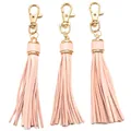 Close-up of three pink faux leather tassels with gold metal lobster clasps for bag charms - Light Pink