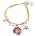 Dettaglio di bracciale intrecciato con margherita viola, stella marina d'argento e campanello - Margherita Viola