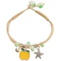 Detail of woven bracelet featuring yellow apple charm, metal star, and green beads - Yellow Apple