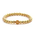 Detail of gold beaded stretch bracelet featuring a yellow round initial M charm - M Letter Style