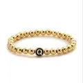 Detailed macro view of the golden bead bracelet featuring a black letter Q pendant charm - Letter Q Style