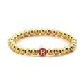 Close-up of a golden beaded elastic bracelet with a pink cylindrical letter R charm - Letter R Grey
