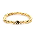 Macro shot of gold-plated metal beads bracelet with a black and gold letter U bead detail - Letter U Style