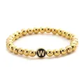 Detail of golden beaded bracelet with black round charm featuring gold letter W engraving - Letter W Black