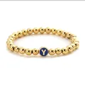 Close-up of golden beaded stretch bracelet featuring a blue round initial Y charm - Letter Y Style