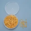 Macro-opname van gouden oogspelden voor DIY-sieraden in een ronde plastic doos - Oogstiften / Goud