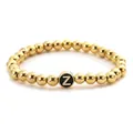 Detail of golden beaded stretch bracelet featuring a black round bead with letter Z - Letter Z Style