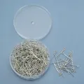 Detail van zilveren oogspelden in een ronde plastic opbergdoos voor DIY-sieraden - Oogstiften / Zilver