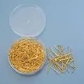 Detailweergave van gouden T-pinnen in een ronde opbergdoos voor DIY sieraden maken - T-stiften / Goud