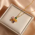 Golden flower pendant necklace with five colorful zircons on beige silk jewelry display - Colorful
