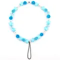 Detailed view of beaded phone strap with blue stars, smiling faces and white pearls - Blue