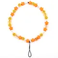 Macro view of colorful beaded phone strap with yellow smiley faces and star beads - Orange