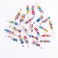 Close-up of DIY capsule pendants with colorful smiley faces and silver metal hooks - Smile Face Pill