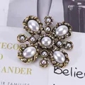 Macro shot of vintage baroque cross brooch with white pearls and sparkling rhinestones - Vintage Cross Floral / Gold
