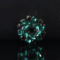 Detail of dark green crystal flower brooch with gold plating on black textured background - Green