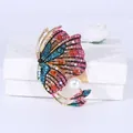 Vintage gouden vlinderbroche met kleurrijke strass-steentjes en een grote witte parel - Roze
