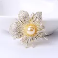 Macro detail of orchid brooch with radiant gold petals, zircon pavé, and center pearl - Gold
