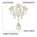 Baroque royal style brooch with oval zircon and white pearl dangle on white background - Gold