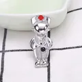 Close-up of nurse figurine brooch with stethoscope and red cross detail on plaid cloth - Silver