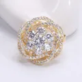 Détail macro d'une élégante broche fleur plaquée or avec zircons et pétales évidés - Or