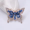 Détail macro d'une broche papillon en émail avec cristaux bleus et ailes serties de diamants - Bleu