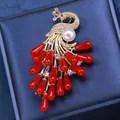 Peacock brooch in gold finish with white pearls and red water-drop shaped accents - White
