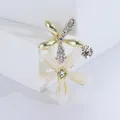 Elegante goldene Blumenbrosche mit weißen Blütenblättern und Kristallen auf weißem Grund - Weiß