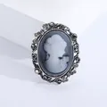 Macro shot of retro cameo brooch with vintage silver frame and sparkling rhinestones - Gray