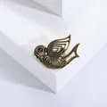 Broche oiseau vintage en bronze antique avec œil en pierre noire sur socle blanc - Or