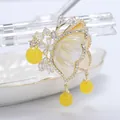 Eleganter Schmetterlings-Brosche in Gold mit Perlmuttflügeln und gelben Perlenanhängern - Braun