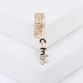 Creative gold comb brooch with rhinestones and black enamel detail on a white pedestal - Gold