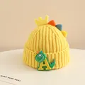 Close-up of yellow knit baby hat with cartoon dinosaur and letter A embroidery - 2-6 Years Old / Yellow