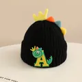 Detailed close-up of children's black knit hat with 3D crown and dinosaur patch - 2-6 Years Old / Black