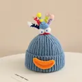 Close-up of blue knit hat with cartoon big eyes, orange mouth, and colorful spiral details - 2-6 Years Old / Blue