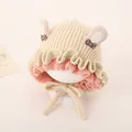Detail of cream knit baby hat featuring cute rabbit ears and decorative polka dot bows - Rabbit Ears Style / Deep Beige