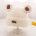 Detail der flauschigen Teddy-Fleece-Babymütze in Creme mit Bärenohren und Leder-Label - Einheitsgröße (3-10 Jahre) / Hellbeige