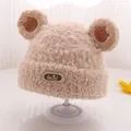 Nahaufnahme der flauschigen Baby-Strickmütze mit Bärenohren und Social-Lederaufnäher - Einheitsgröße (3-10 Jahre) / Khaki