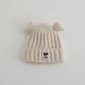 Detail of baby winter knit hat with cute round ears and a decorative fashion label - Baby 2-7 Years / Beige