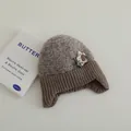 Taupe-braune Kinder-Strickmütze mit Ohrenklappen und Plüschblume für den Winter - Stil 2 (Blume/Stern) / Grau
