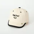 Beige katoenen honkbalpet voor peuters met Hello-borduurwerk en een zwarte rand - Hello Smile Stijl / Beige