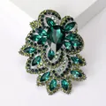 Macro shot of vintage crystal flower brooch with emerald green stones and silver alloy base - Green
