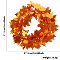 Detail showing a 27.5cm orange maple leaf tinsel wreath with weights for Thanksgiving - Diameter 27.5cm / Gold