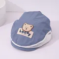 Detail van lichtblauwe kinderpet met ademend gaas en een schattige pluche beer-applicatie - 50-52CM / Blauw