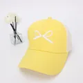 Dettaglio del cappellino giallo con ricamo fiocco bianco e rete traspirante sul retro - Taglia per Bambini / Giallo