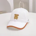 Detail of breathable mesh kids' baseball cap featuring embroidered bear patch and brown trim - Adjustable Kids Size / White
