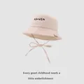 Detail of baby sun hat featuring RANHSR embroidery and adjustable beige chin strap - 48-50cm / Beige