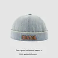 Detailed close-up of brown BOSTON embroidery on a light blue denim baby skullcap hat - 48-50cm / Light Blue BOSTON