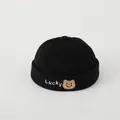 Close-up of black corduroy baby beanie with Lucky embroidery and a brown bear patch - Toddlers 2-5 Years 50-52CM / Black