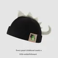 Black corduroy kids dinosaur beanie with green plush fins and cartoon patch detail - Baby Size / Black