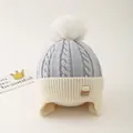 Detail of warm knit kids hat with fuzzy pompom and soft thick fleece lining texture - One Size / Grey Blue